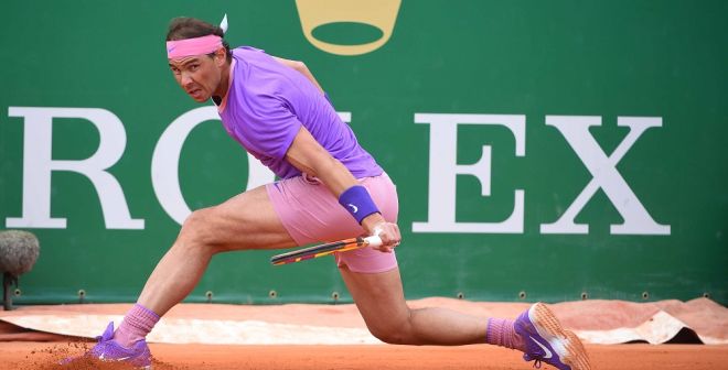 Rafa Nadal slides into a backhand return on red clay